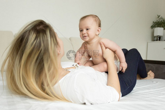 年轻微笑的女人和儿子玩耍的肖像图片