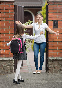 快乐的女学生在放后跑向母亲等待的到来图片