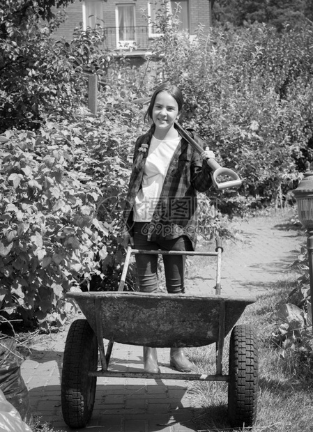 开心女孩在花园里用手推车的黑白照片图片