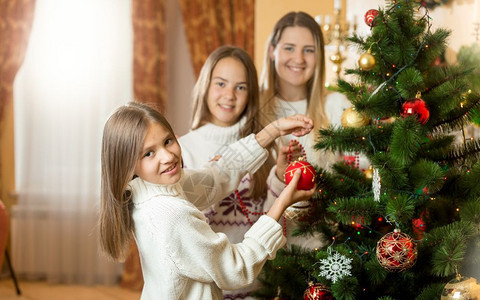 在客厅装饰圣诞树的家庭快乐笑容图片