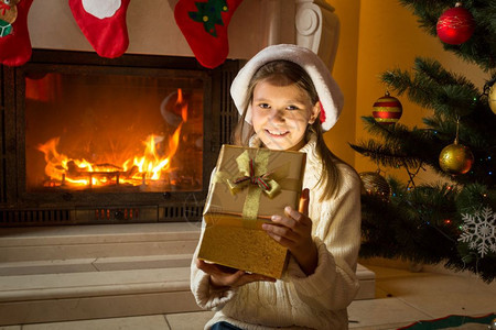10岁快乐的小女孩看着神奇的圣诞礼物盒图片