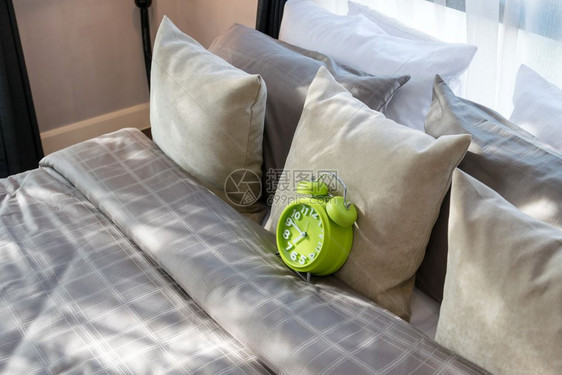现代卧室绿色闹钟和床上枕头图片