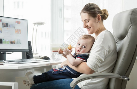 在家工作和照顾婴儿的年轻自雇母亲图片