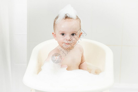 婴儿男孩洗澡时在泡沫中玩耍图片