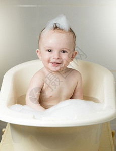 9个月大的婴儿在洗澡时泡沫中玩耍图片