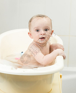 坐在澡堂的可爱笑男孩肖像图片