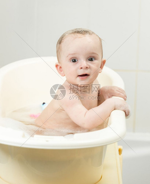 坐在澡堂的可爱笑男孩肖像图片