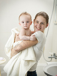 年轻母亲洗完澡后在浴室亲婴儿图片
