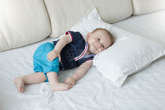 可爱的一岁小孩男放松在大枕头上图片