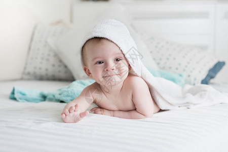 9个月大的婴儿躺在床上白毛巾下图片