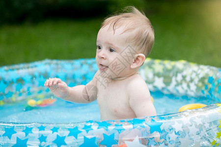 男孩在花园游泳池玩得开心图片