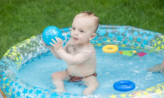 9个月大的婴儿男孩在户外游泳池玩图片