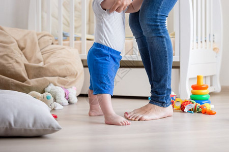 适合的婴儿和可亲的配额和母亲rs的配额在起居室地板上的脚图片