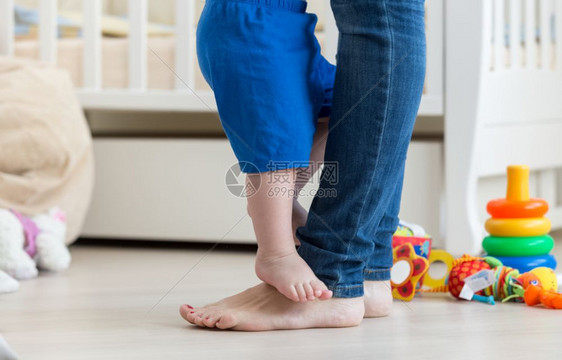 婴儿和rrsquuo站在地板上母亲脚前的下婴儿和婴儿和图片