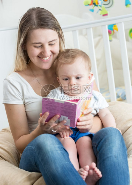 美丽快乐的母亲和她男孩儿一起读书图片