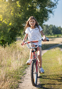 在草地骑自行车的女孩图片