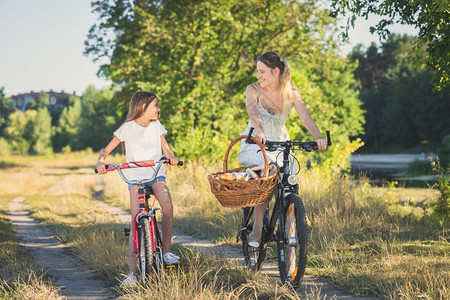 母亲带着女儿骑着自行车去公园野餐图片