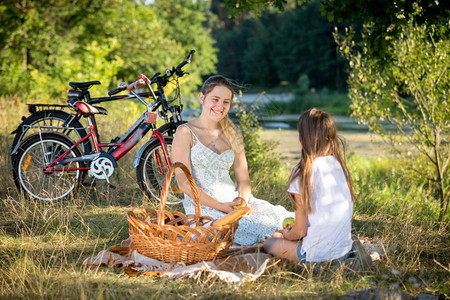 10岁女孩与年轻母亲在河边野餐图片