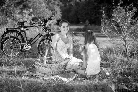 年轻女子在野餐时与儿一起放松的黑白画面图片