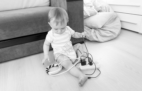 可爱的男孩玩电线延伸和地板游戏的黑白画面图片
