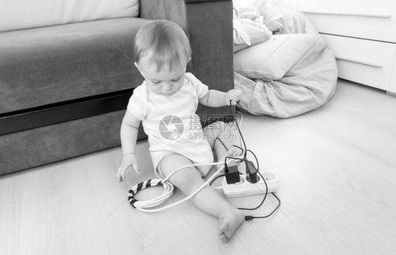 可爱的男孩玩电线延伸和地板游戏的黑白画面图片