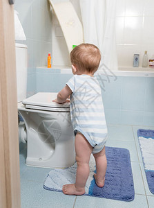 幼儿可爱男孩站在浴室和马桶上玩耍图片