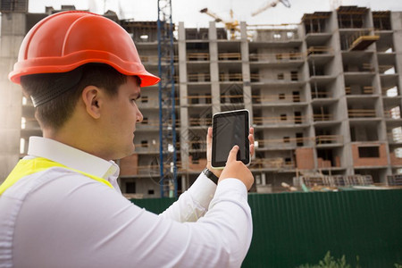 使用建筑工地数字石板的青年建筑工程师图片