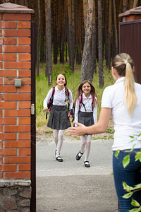 两个快乐的女孩放学后跑去找母亲图片