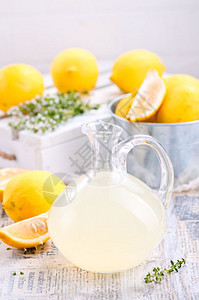 在玻璃壶和桌子上喝新鲜柠檬汁图片
