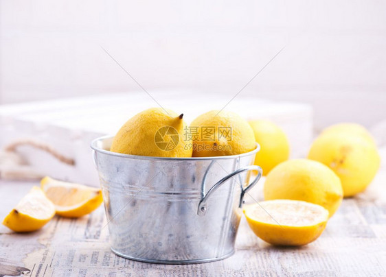金属碗和桌上的新鲜柠檬图片
