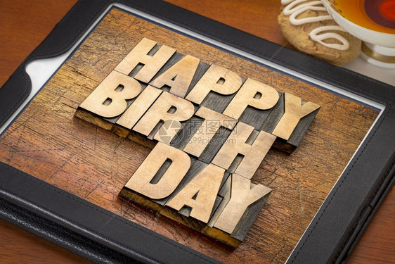生日快乐贺卡数字平板上带有一杯茶和饼干的纸质木头型文字摘要图片