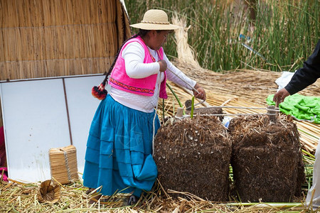 PERU2015年月日205年月日不明身份的穿传统服装妇女欢迎乌罗斯岛的游客图片