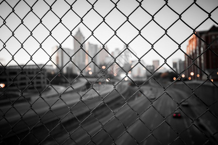 穿过铁丝网栅栏的城市天线抽象模糊的城市景色背图片