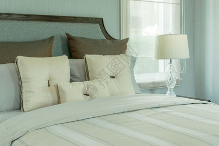 室内舒适有白色枕头和床边桌上的阅读灯图片