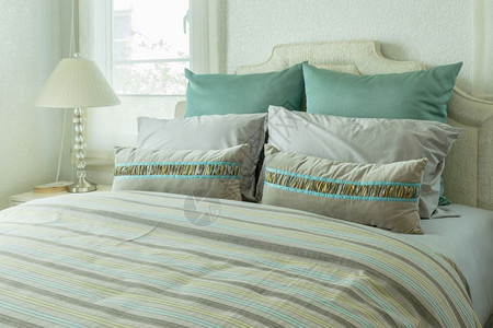 室内舒适的卧有绿色枕头和床边桌的阅读灯图片