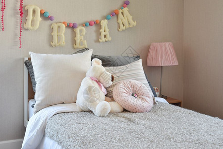 床上有洋娃和枕头的现代儿童房图片