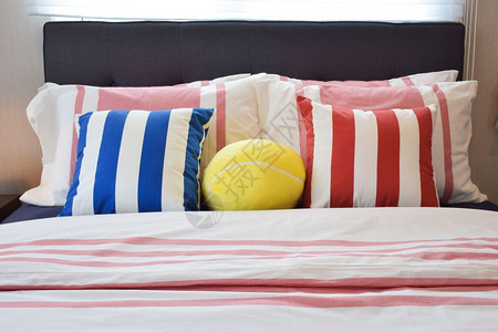 现代卧床上有蓝色和红带条纹枕头图片