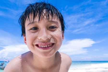 一个男孩在海滩上微笑图片