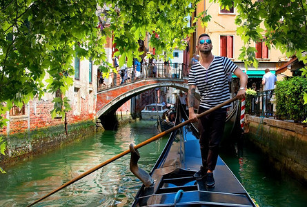 在意大利威尼斯街上乘坐歌多拉时英俊的帅哥威尼斯Gondolier图片