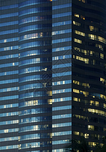 夜间照亮的办公大楼窗背景图片