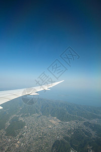 飞越海面上空的飞机机翼图片