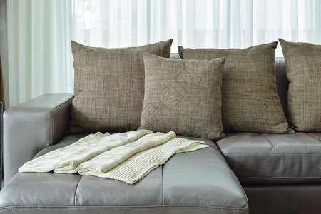 现代客厅的灰色皮革沙发和棕枕头图片