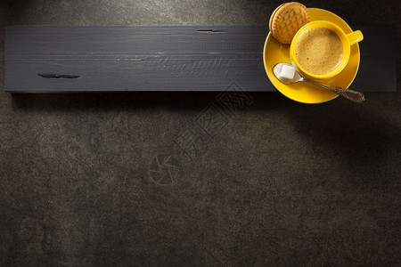木板背景的黄色茶杯图片