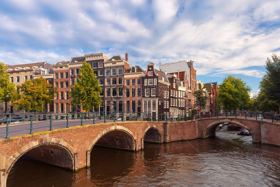 阿姆斯特丹运河Reguliersgracht荷兰在阳光明媚的早晨荷兰典型的码头房屋桥梁和船图片