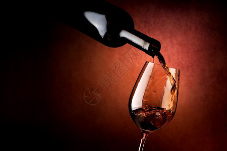 棕色背景的葡萄酒倒在杯里图片