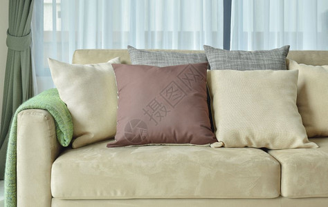 浅棕色皮面沙发上的棕色枕头图片