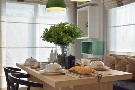 用漂亮的花瓶和现代椅子在木制桌上安装早餐图片