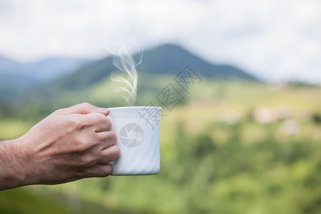 在大自然户外背景上手握咖啡杯图片