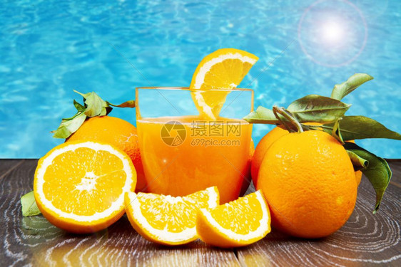 鲜橙汁和木底子的玻璃杯图片