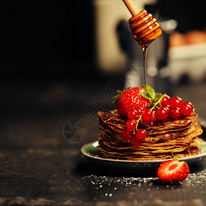 早餐套自己做的煎饼鲜莓果和蜂蜜放在黑木桌的生锈盘子上图片